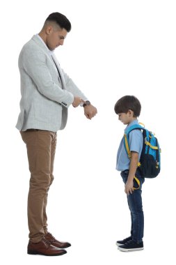 Öğretmen beyaz arka plana geç kaldığı için öğrenciyi azarlarken, bilek nöbetini işaret ediyor.
