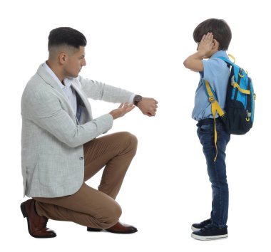 Öğretmen beyaz arka plana geç kaldığı için öğrenciyi azarlarken, bilek nöbetini işaret ediyor.