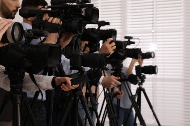 Kameralı bir grup gazeteci içeride resmi kişiyi bekliyor, yakın çekim