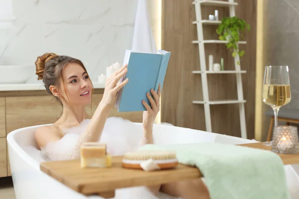 Piękna Kobieta Czyta Książkę Podczas Korzystania Kąpieli Bąbelkowej Domu — Zdjęcie stockowe