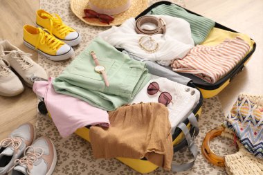 Giysilerle dolu bir bavul ve ayakkabılarla dolu yaz aksesuarları.