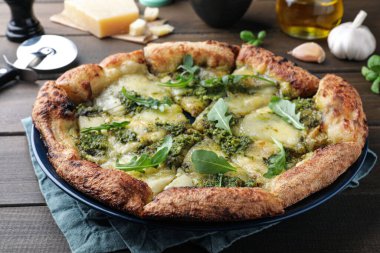 Ahşap masada pesto, peynir ve roka ile nefis pizza, yakın plan.