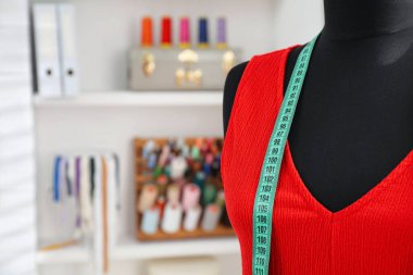 Elbiseli manken ve terzi stüdyosunda mezura. Metin için boşluk