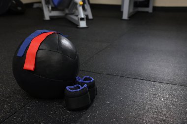 Siyah tıp topu, elastik bantlar ve spor salonunda yerde tartı ajanları, mesaj atmak için yer.
