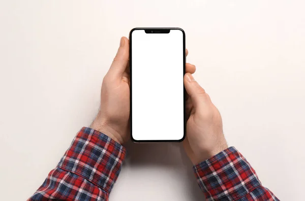 白い背景のスマートフォンを持つ男 トップビュー — ストック写真