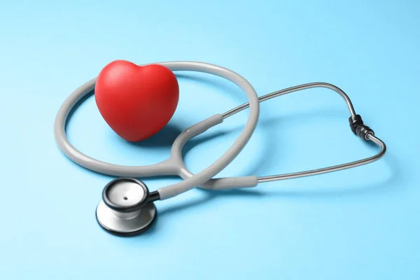 听诊器和红色装饰心脏浅蓝色背景 心脏科概念 — 图库照片