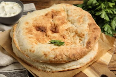 Ahşap masada nefis ev yapımı pide ekmeği, yakın plan.