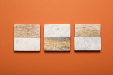 Turuncu arka planda şık bardak altlıkları, düz yatış