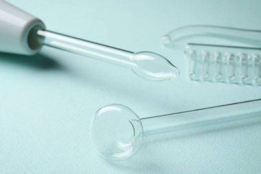 Turkuaz arka planda farklı nozüllere sahip Darsonval, yakın plan