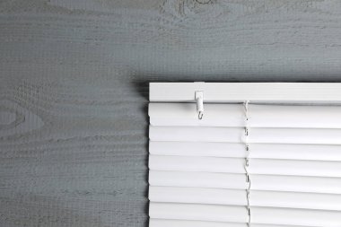 Gri ahşap masa üzerindeki yatay pencere perdeleri, üst manzara. Metin için boşluk
