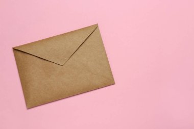 Pembe arka planda kahverengi zarf, üst manzara. Metin için boşluk