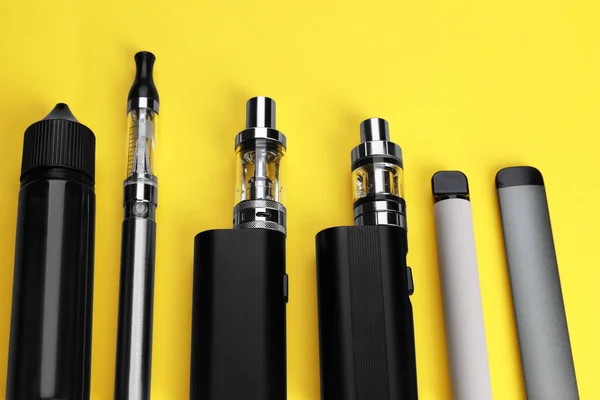 Verschiedene Elektronische Zigaretten Auf Gelbem Hintergrund Oben Ansicht — Stockfoto