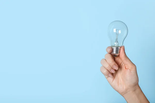 Mujer Sosteniendo Bombilla Incandescente Sobre Fondo Azul Primer Plano Espacio — Foto de Stock