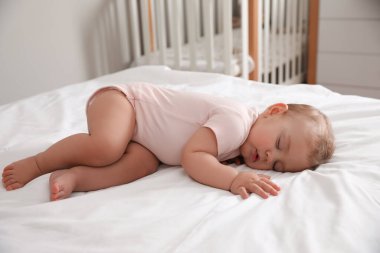 Sevimli küçük bebek evde yatakta uyuyor.