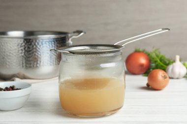 Lezzetli çorbayı beyaz ahşap masada süzmek.