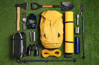 Yeşil çimlerin üzerinde seyyah ekipmanları, düz yatıyordu.