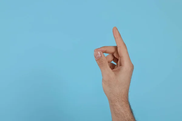 Homem Apontando Para Algo Fundo Azul Claro Perto Mão Espaço — Fotografia de Stock
