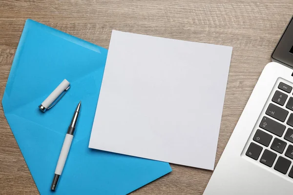 Lichtblauwe Envelop Met Blanco Brief Pen Laptop Houten Tafel Plat — Stockfoto