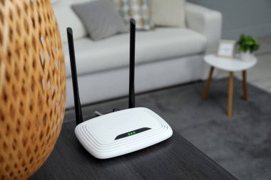 Odadaki siyah ahşap masadaki Wi-Fi yönlendirici.