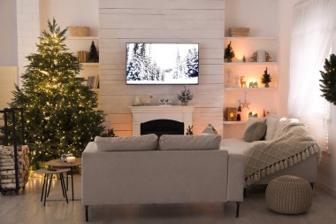 Güzel bir Noel ağacı ve şöminesi olan samimi bir oturma odası.