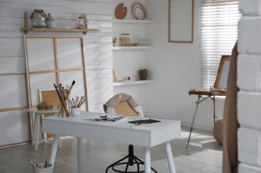 Sanatçının iş yeri ve sanat malzemeleriyle modern stüdyo içi