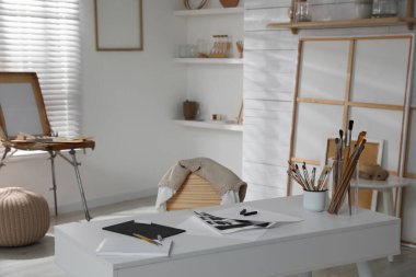 Sanatçının çalışma yeri ve ahşap sehpası olan modern bir stüdyo.