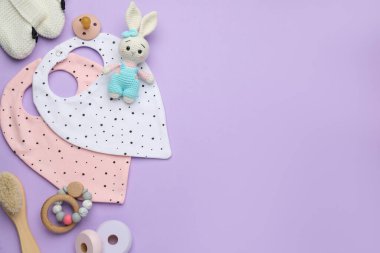 Bebek aksesuarları ve önlükleriyle menekşe arkaplan üzerinde düz kompozisyon, metin için boşluk