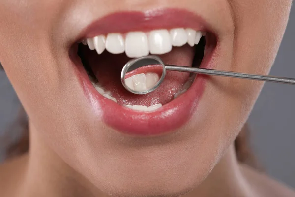 배경에 의사의 거울로 여성의 치아를 진찰하는 — 스톡 사진