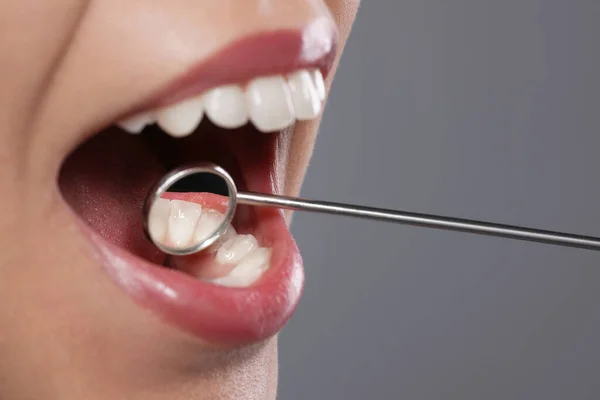 Вивчення Зубів Жінки Дзеркалом Стоматолога Сірому Фоні Крупним Планом — стокове фото