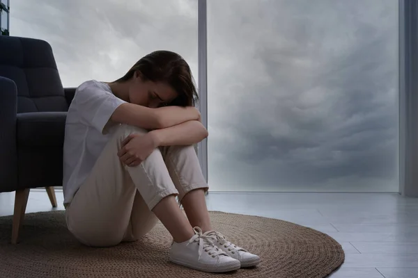 悲しい若い女性の床に自宅で テキストのためのスペースに座っている 孤独の概念 — ストック写真