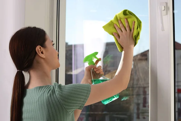 Jovem Mulher Limpeza Janela Vidro Com Pano Detergente Casa — Fotografia de Stock