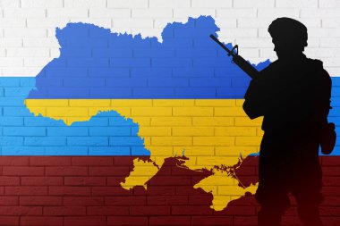 Rus-Ukrayna savaşı. Ukrayna ve Rus bayrağının ana hatlarıyla tuğla duvara dayalı asker silueti.