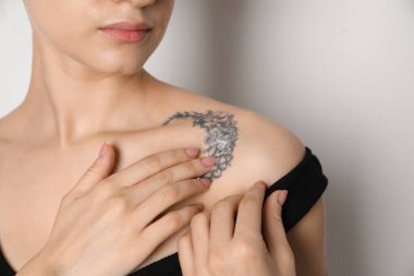 Cildine krem süren bir kadın, arka planda ışığa karşı, yakın plan.