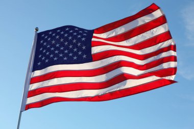 Güneşli bir günde Amerikan bayrağı dalgalanıyor.