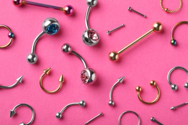 Pembe arka planda piercing mücevherleri, düz yatış.