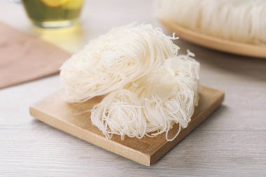 Ahşap masada pişmemiş pirinç erişteleri, yakın plan.