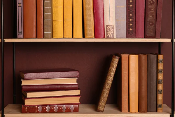 Planken Met Verschillende Boeken Bruine Muur — Stockfoto