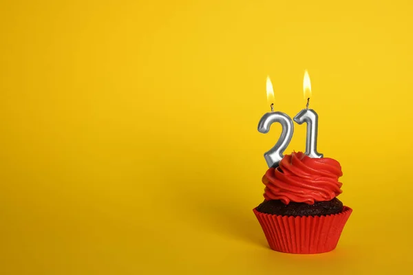 美味的纸杯蛋糕 黄色背景上有数字形状的蜡烛 文字空间 成年派对 21岁生日 — 图库照片