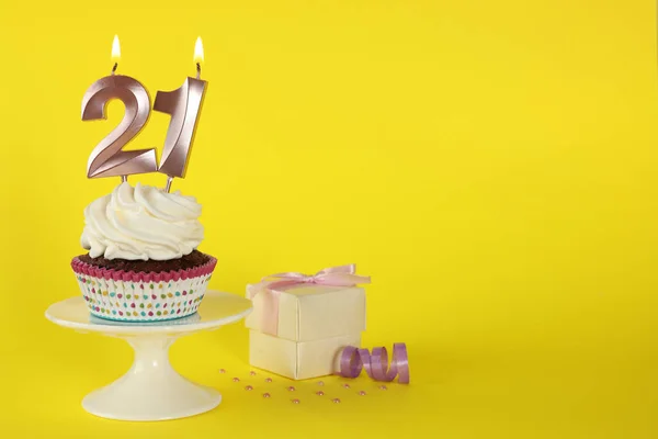 美味的纸杯蛋糕 黄色背景上有数字形状的蜡烛 文字空间 成年派对 21岁生日 — 图库照片