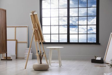 Resim sehpası ve fırçalarla donatılmış bir stüdyo.