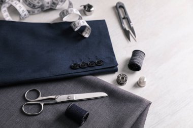 Beyaz masada dikiş malzemeleri ve aksesuarlar var.