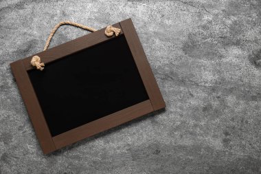 Gri masadaki temiz, küçük siyah karatahta, üst manzara. Metin için boşluk