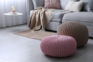 Oturma odasındaki kanepenin yanında süslü püslü puflar. Metin için boşluk