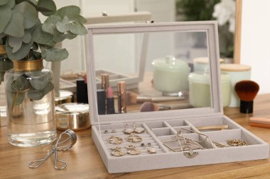 Zarif mücevher kutusu, güzel bijouterie, kozmetik ve ahşap masa üzerinde mumlar.