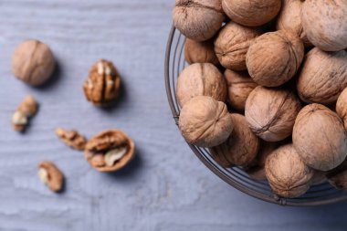 Gri ahşap masada olgun cevizli metal sepet, üst manzara. Metin için boşluk