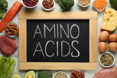 Açık gri masa üzerinde amino asit açısından zengin ürünlerle düz konum
