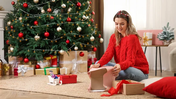 Beautiful Young Woman Wrapping Christmas Gifts Home Stock Photo by