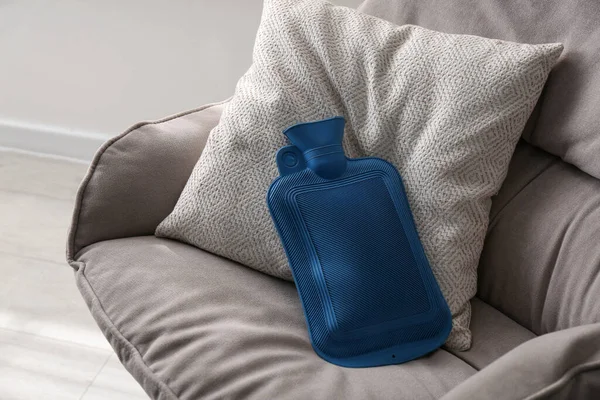 在室内扶手椅上的橡胶热水瓶 — 图库照片