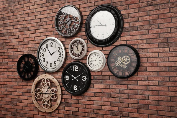 Kolekcja Zegarów Wiszących Ścianie Czerwonej Cegły — Zdjęcie stockowe