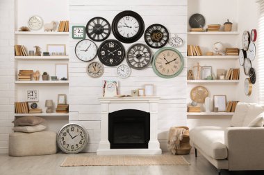 Rahat kanepe, şömine ve duvar saati koleksiyonu olan şık bir oda.